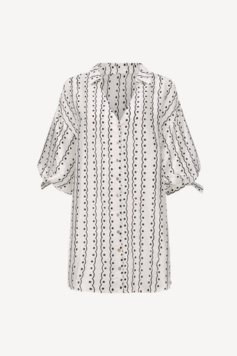 A white short-sleeve blouse with a black vertical dotted and wavy line pattern, featuring a split neckline and tie details at the sleeve cuffs, shown against a light gray background.