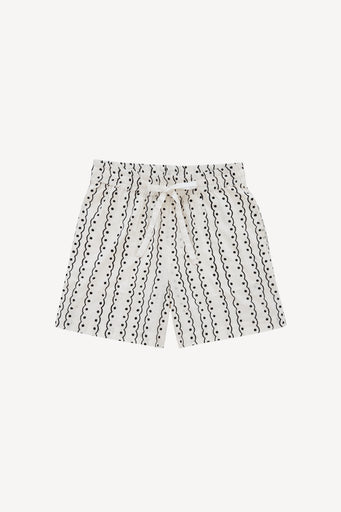 White shorts with a black vertical wavy line pattern and a matching drawstring waist, shown flat on a light gray background.
