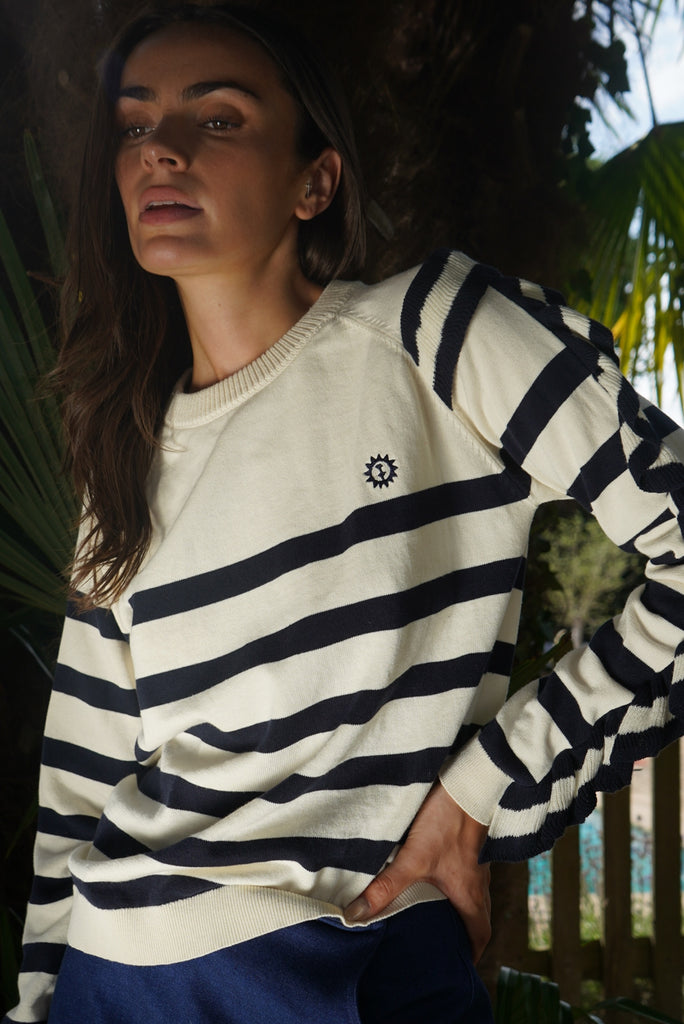 Model wearing our striped Montana Jumper and navy Tennis skirt against greenery