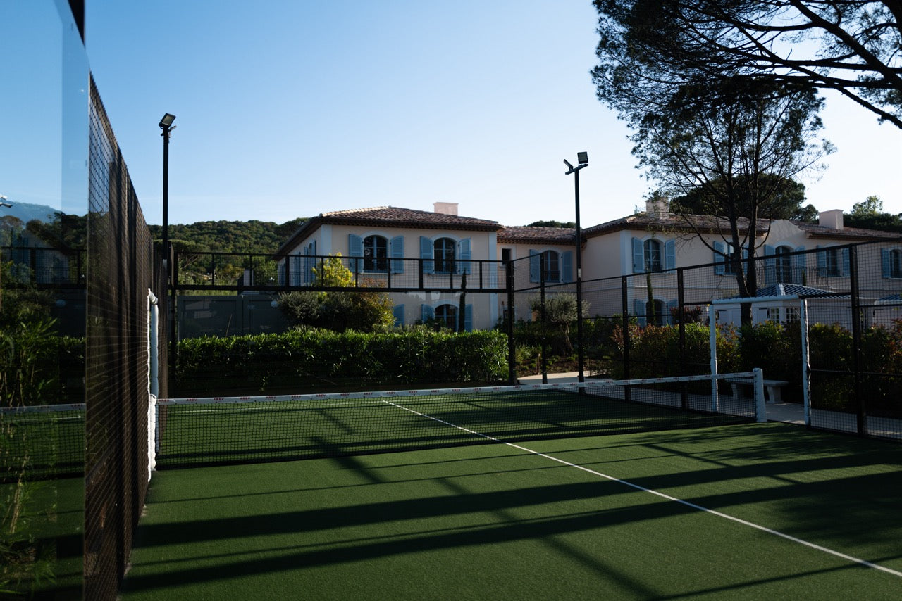 Green padel court with the french style hotel in the background