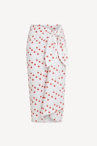 A white sarong with a red cherry print, featuring a tie-waist design and an asymmetrical draped hem, shown against a plain light grey background.