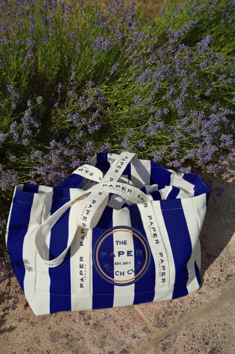 Navy and white striped tote bag with 'The Paper Beach Club' logo with lavender in the background