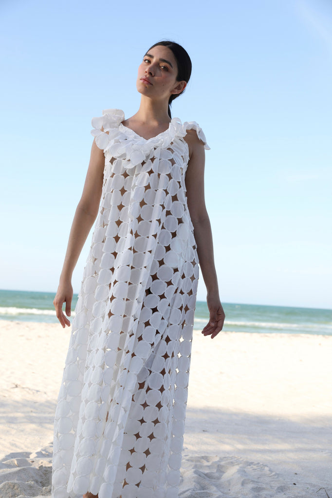 Woman wearing a white crochet dress on a beach